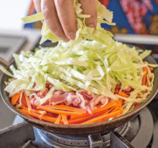 フライパンに豚肉の半量を重ならないように敷き、その上ににんじん・豚肉・キャベツと層にして重ねます。