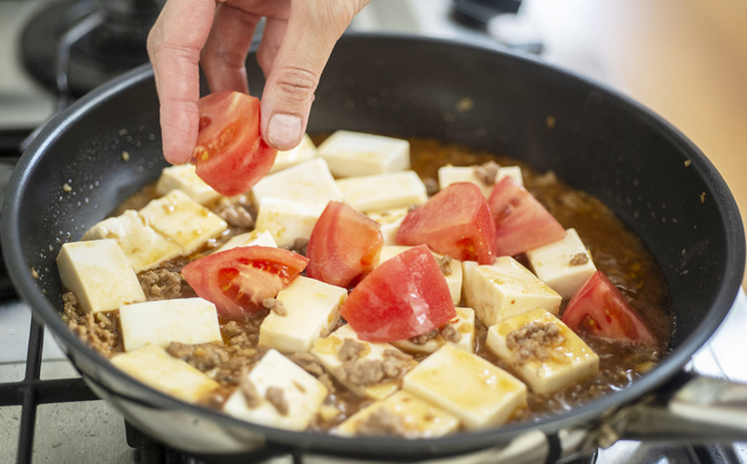 トマトを加え、温まる程度に軽く煮る。Bを加えてとろみを付け、仕上げに長ねぎを加えてさっと混ぜる。