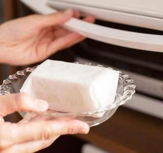 木綿豆腐はキッチンペーパーに包んで耐熱皿にのせ、ラップをせずに600Wの電子レンジで約2分加熱して水切りをします。コーンは水気を切ります。バットに小麦粉を入れておきます。