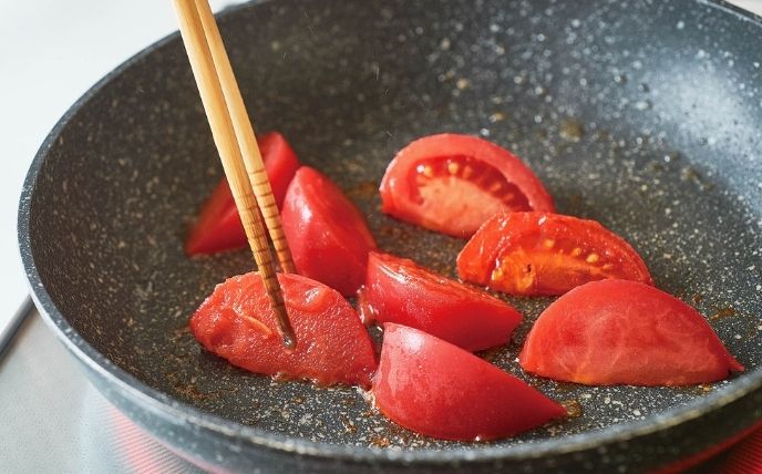 2.のフライパンにトマトを入れ、強めの中火でさわらずに焼く。トマトの皮の端が少しめくれてきたら裏返してさらに焼く。