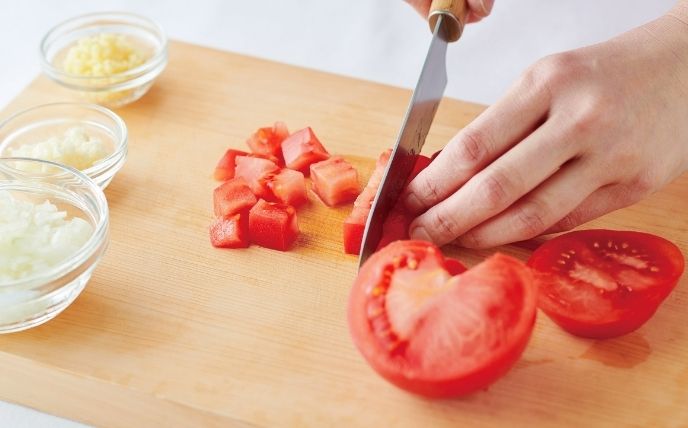 玉ねぎ・にんにく・しょうがはみじん切りにする。トマトは1.5cm角のざく切りにし、トッピング用に1/4個分を取り分けておく。大葉は千切りにする。