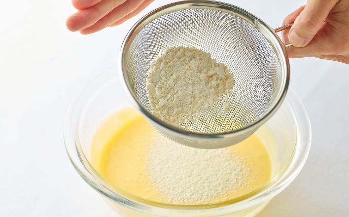ボウルにクリームチーズを入れて泡立て器でなめらかになるまで混ぜる。砂糖・卵・ヨーグルト・レモン汁を順に加えて、その都度よく混ぜる。<br>小麦粉をふるい入れて、全体になじむまで混ぜる。