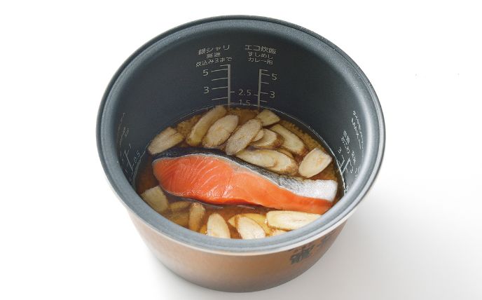炊飯器の内釜に米とだしつゆを入れて、水を1合の目盛りまで入れる。鮭・ごぼうを入れて炊飯する。