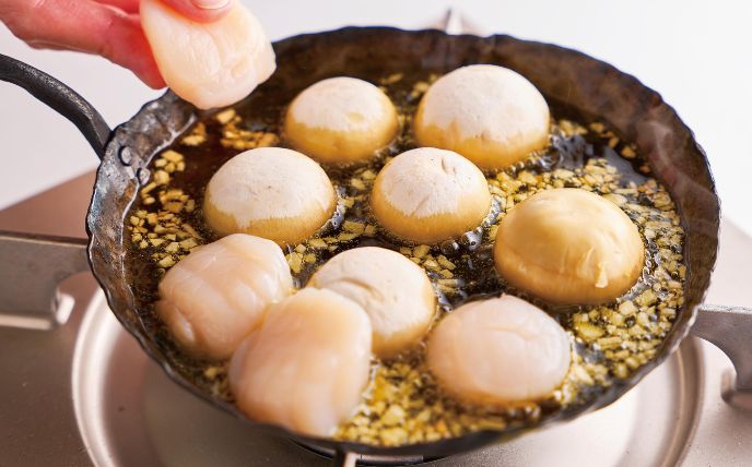 小さめのフライパンにオリーブオイル・にんにくを入れて弱火にかける。香りが出たらほたてとマッシュルーム・Aを入れて軽く煮る。パセリを散らし、パンを添える。