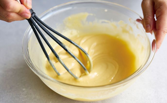 卵黄生地を作る<br>
耐熱ボウルに油を入れて、ラップをせずに600Wの電子レンジで約20秒加熱する。ホットケーキミックスを加えて泡立て器でよく混ぜ、卵黄を1個ずつ加えてよく混ぜる。豆乳を2回に分けて加えながらなめらかになるまで混ぜる。