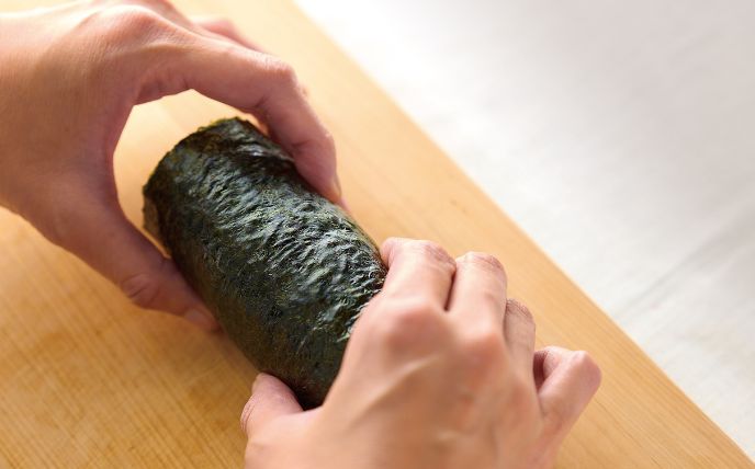 巻き終わりを下にして、５分ほどそのままおいて落ち着かせる。もう１本も同様にして作る。食べやすく切って盛り付け、しょうゆ・わさびを添える。<br>
※水を含ませたキッチンペーパーで包丁を軽くぬらすと切りやすい。

